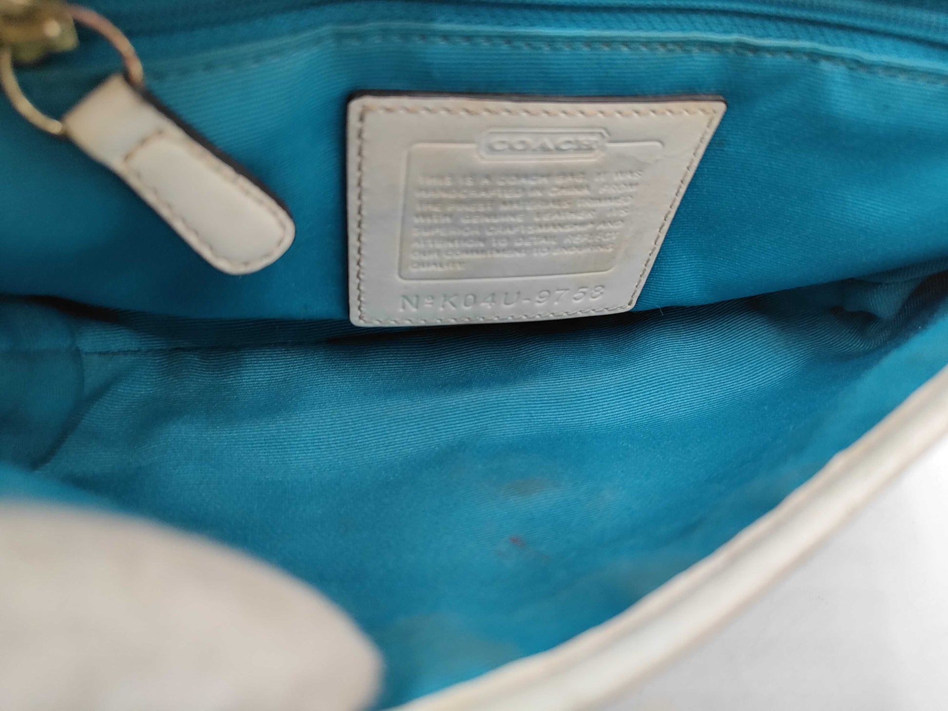 Close-up of a blue interior of a bag with a Coach label.