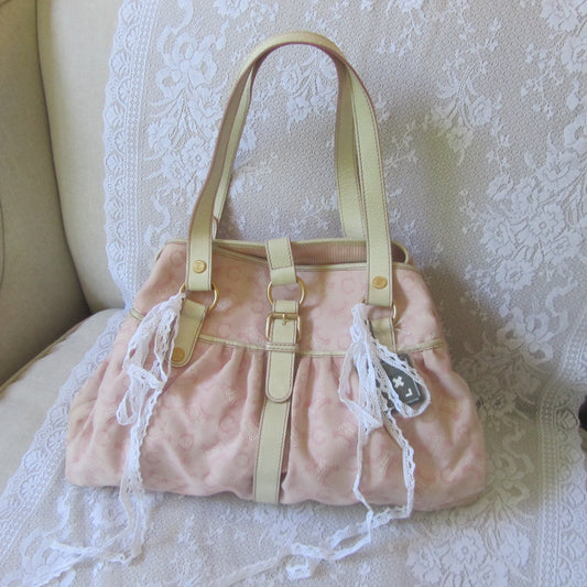 Pink handbag with lace details on a white lace chair