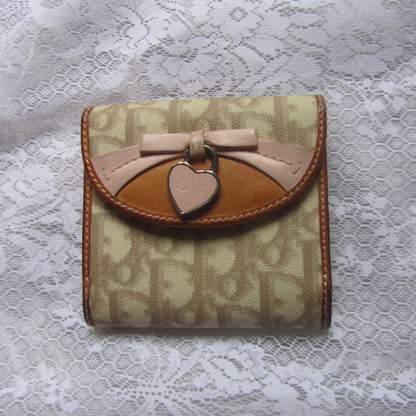 Small wallet with a bow and heart charm on a lace background