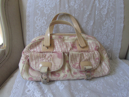 Floral patterned handbag with beige accents on a lace-covered surface