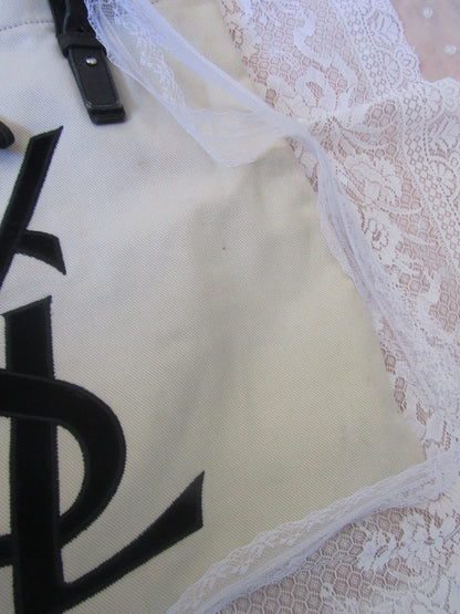 White bag with black text on a lace background