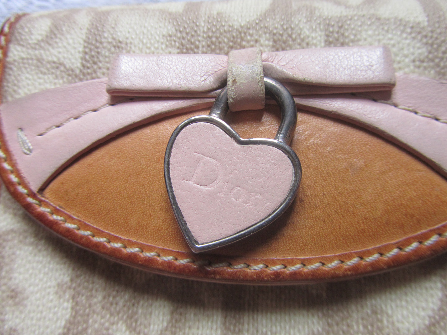 Heart-shaped keychain with 'Dior' logo on a textured surface