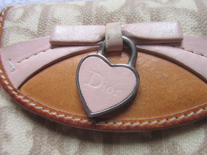Heart-shaped keychain with 'Dior' logo on a textured surface
