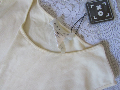 Beige tank top with a tag on a lace fabric background