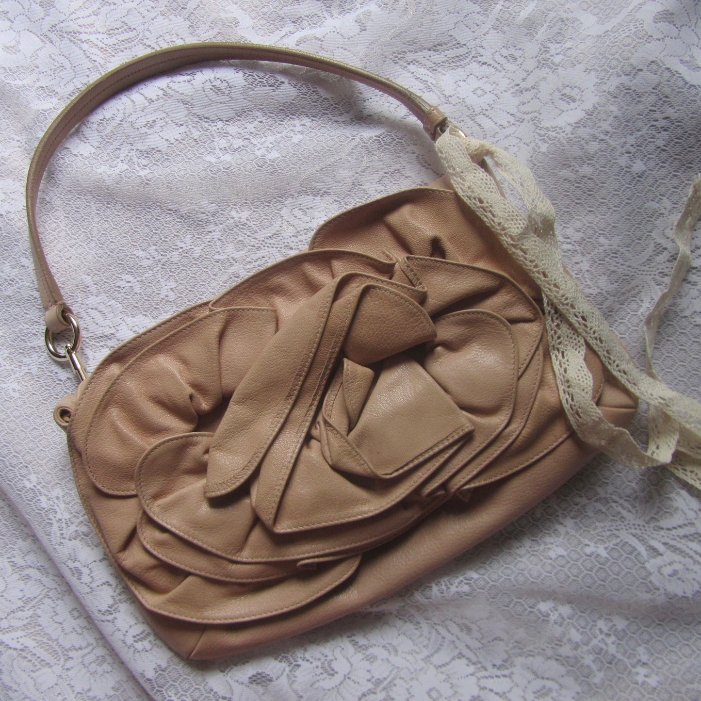 Beige handbag with floral design on a textured surface