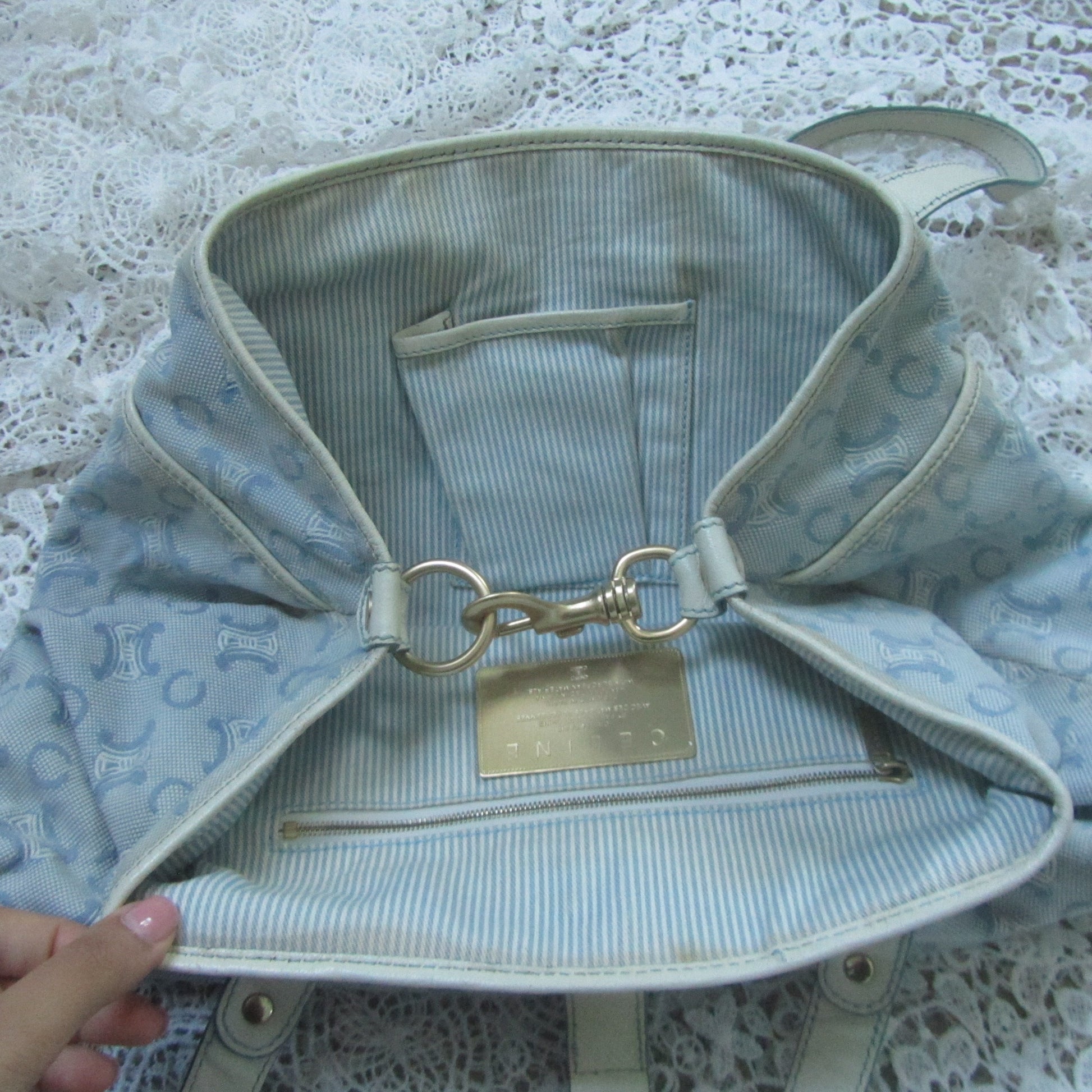 Light blue bag with a gold clasp on a lace background
