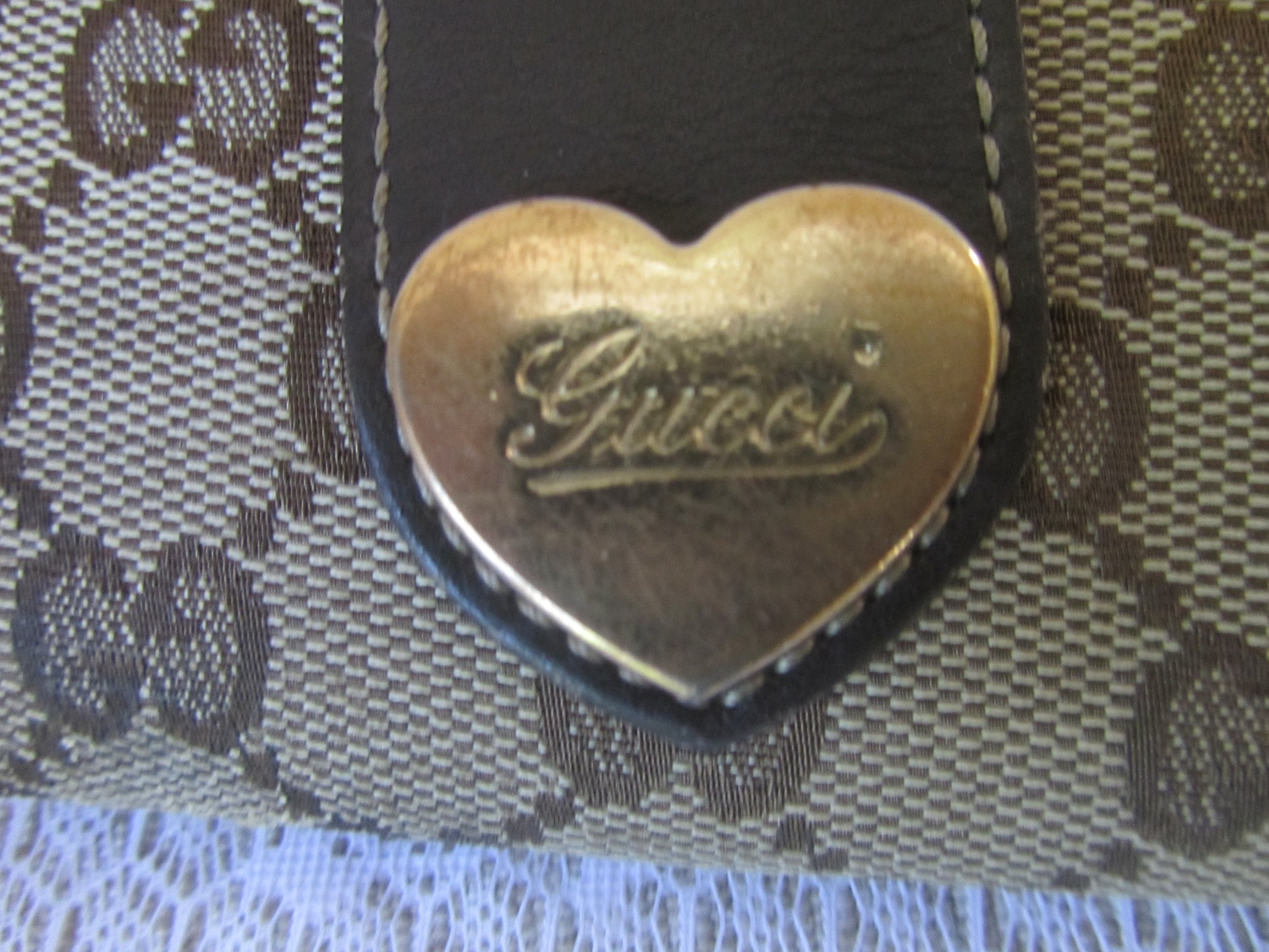 Heart-shaped Gucci logo on a textured fabric background