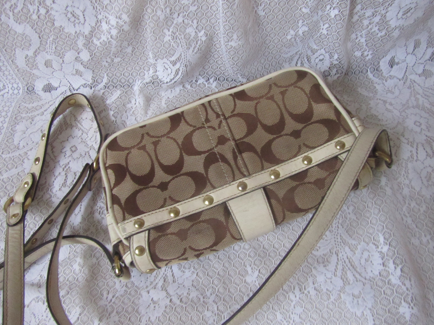 Coach handbag with logo pattern on a textured white background