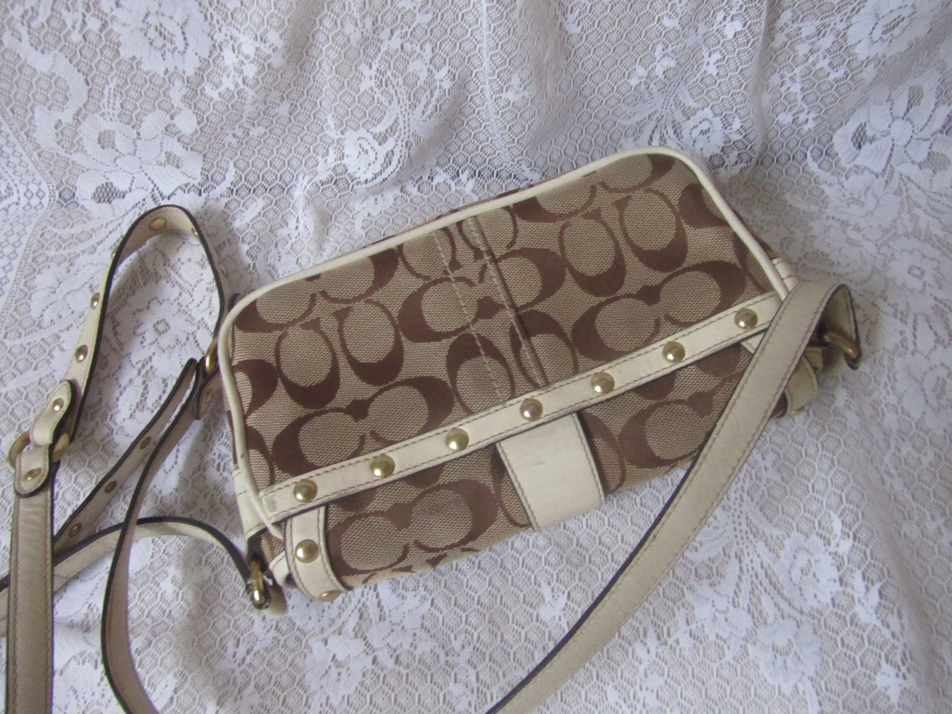 Coach handbag with logo pattern on a textured white background