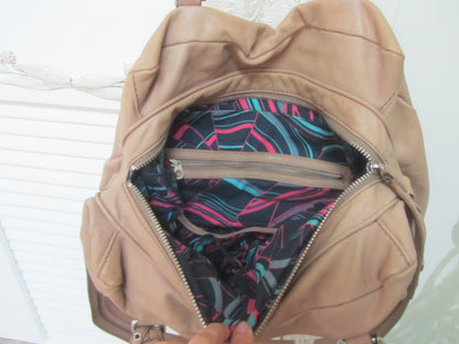 Beige backpack with colorful interior lining on a white background