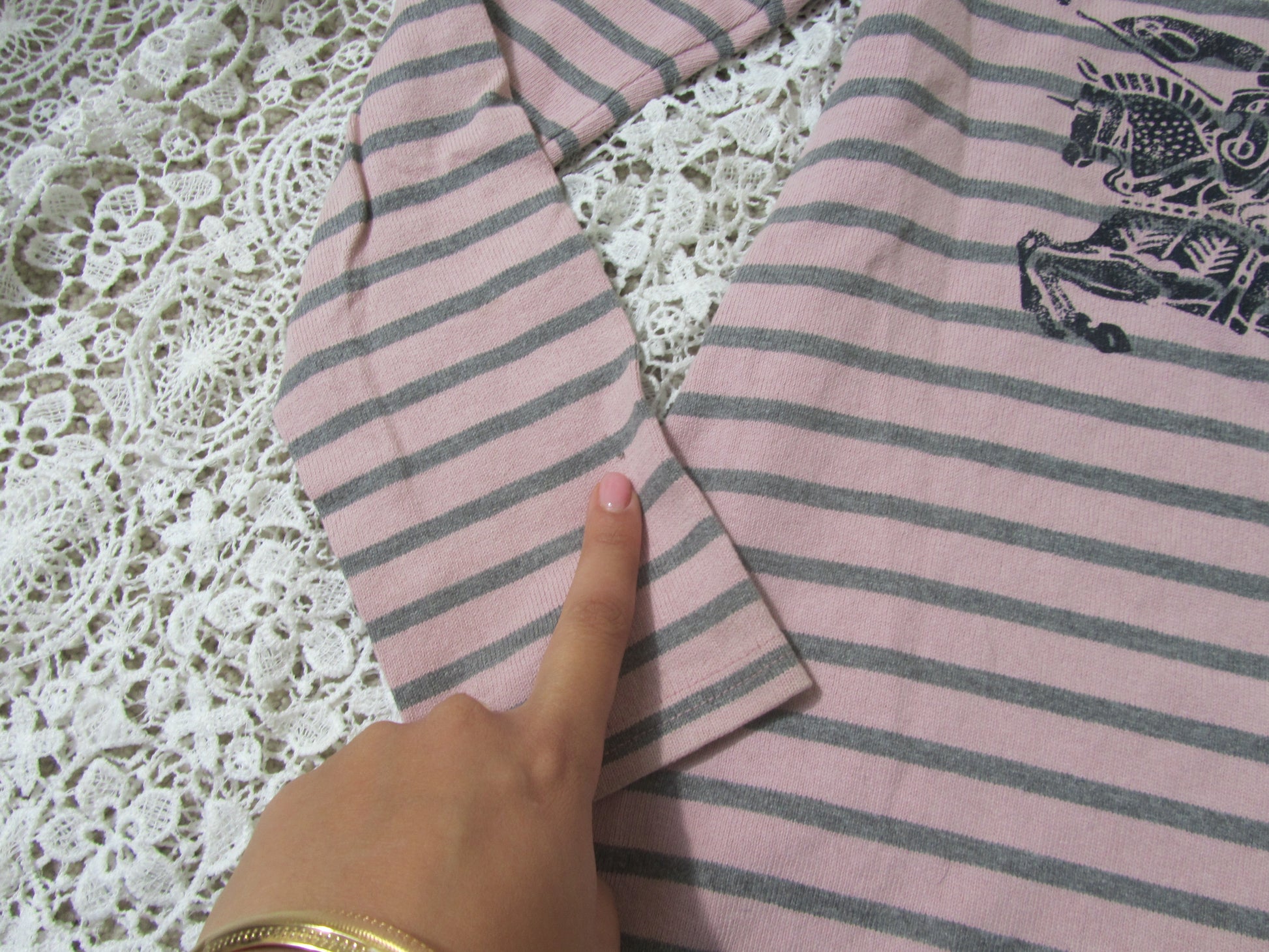 sleeve of a pink striped dress on a lace background