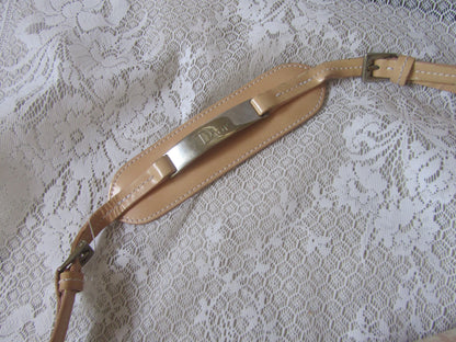 Beige leather strap with metal buckle on a lace background