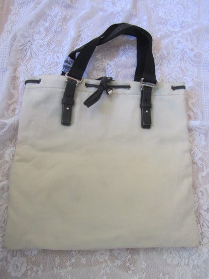 Beige tote bag with black straps on a textured white background