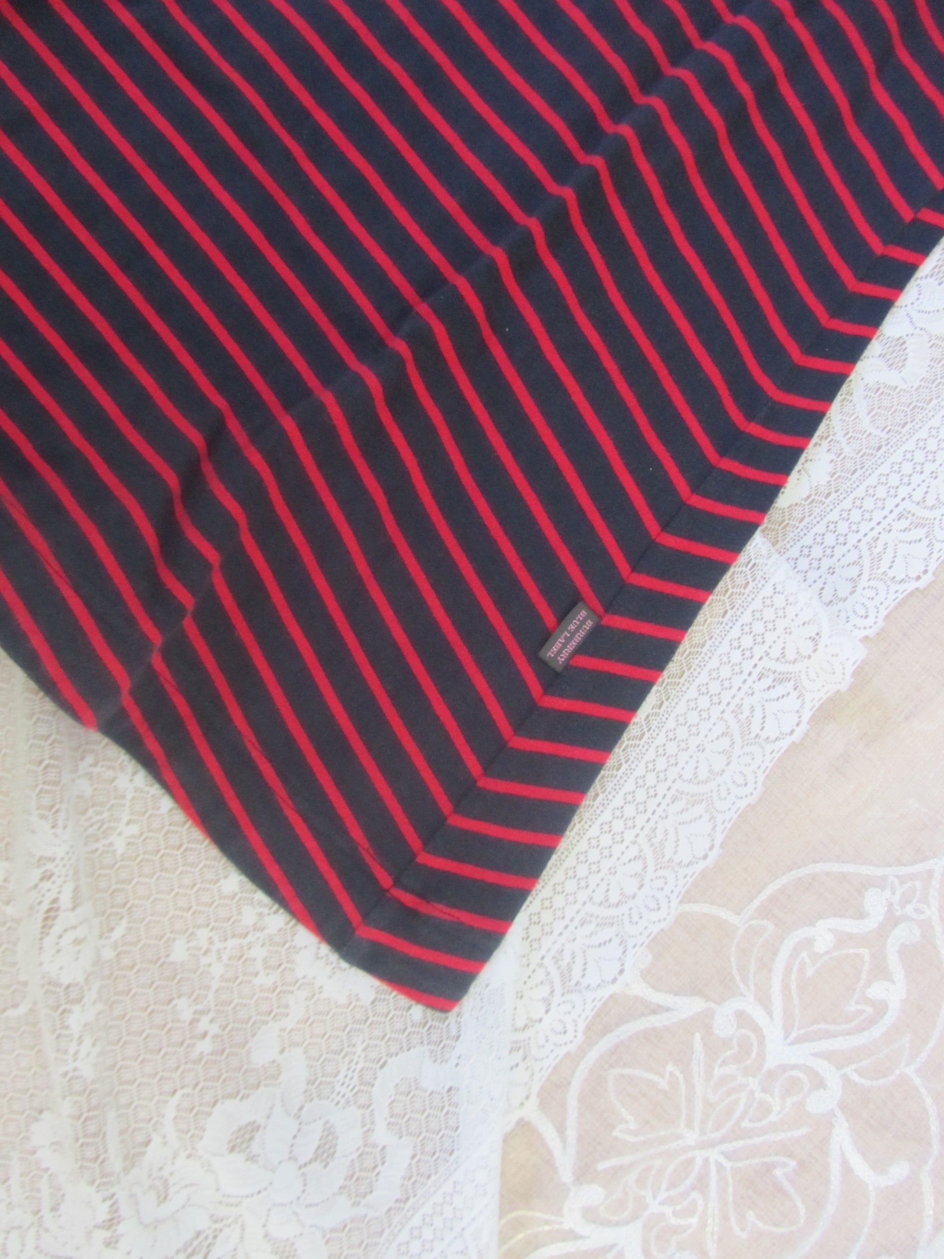 Black and red striped fabric on a textured white surface