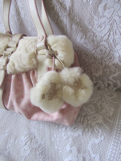 Pink pom poms with fur trim on a textured surface