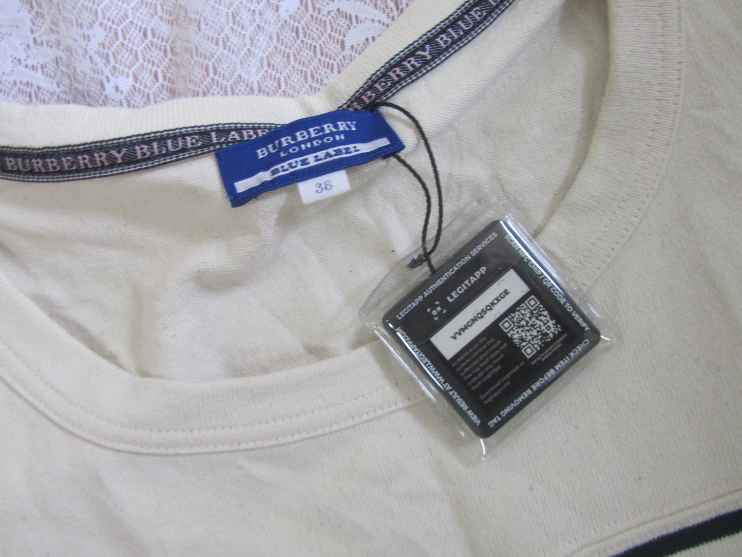 Close-up of a Burberry label on a beige garment with a QR code tag.