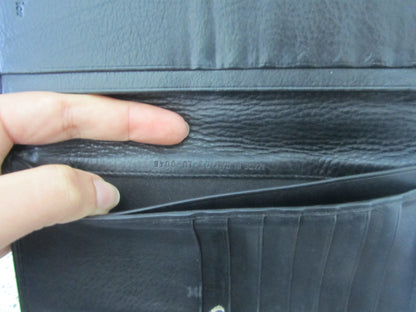 Close-up of a black leather wallet with a hand opening it