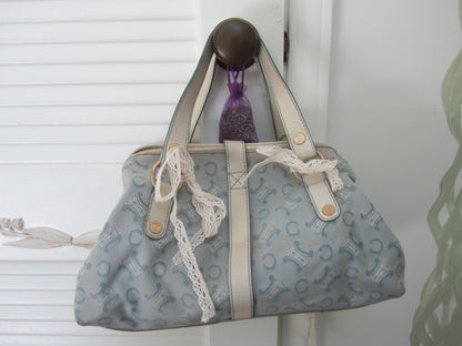 Patterned handbag with lace trim hanging on a white door handle.