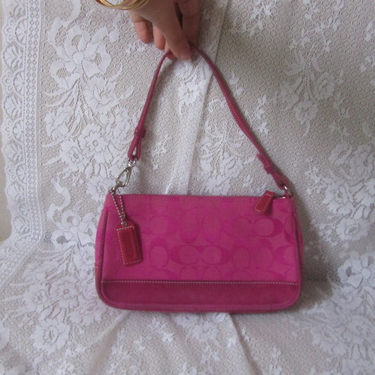 Pink handbag with a visible brand logo on a white lace background