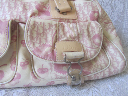 Pink floral patterned handbag with visible brand logo on a textured surface