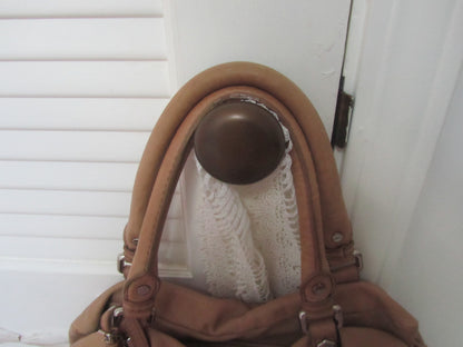 Brown leather handbag with a metal clasp on a white background