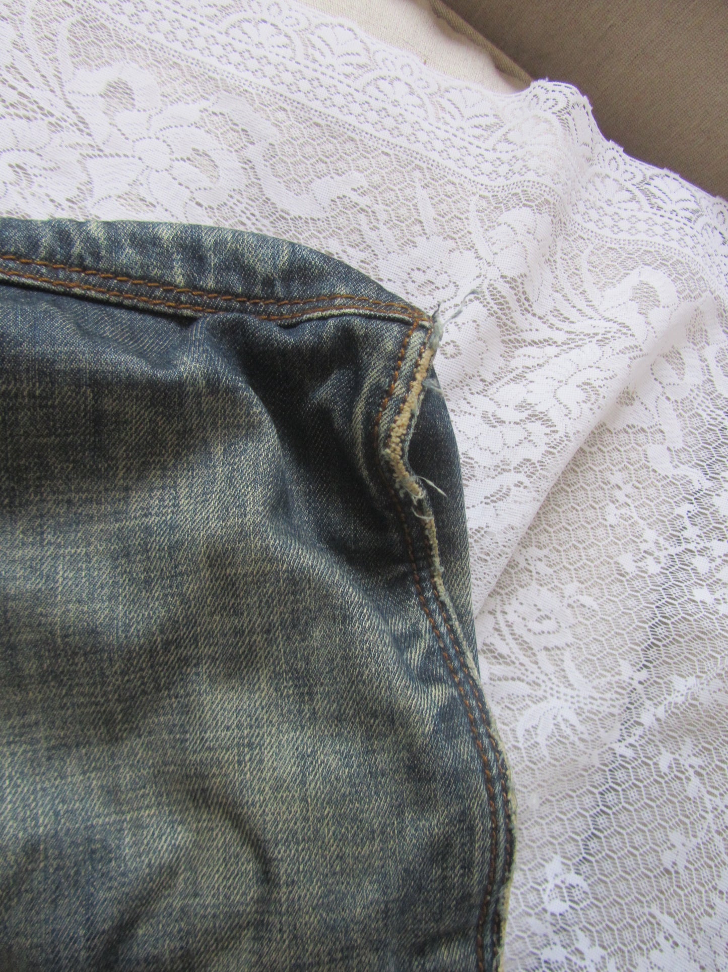 Close-up of blue denim fabric with a lace background