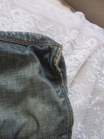 Close-up of blue denim fabric with a lace background