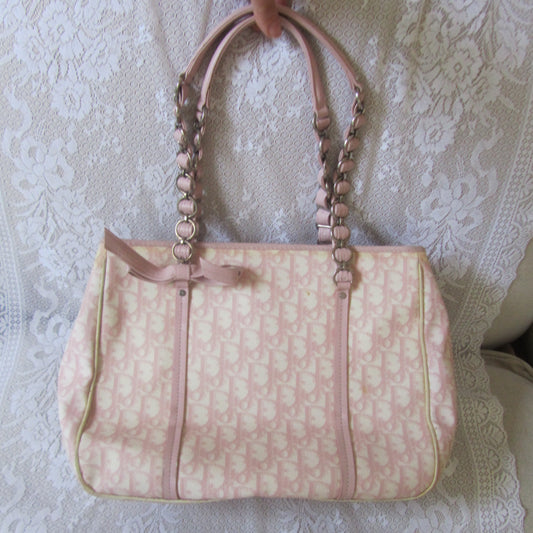 Pink patterned handbag on a textured white surface
