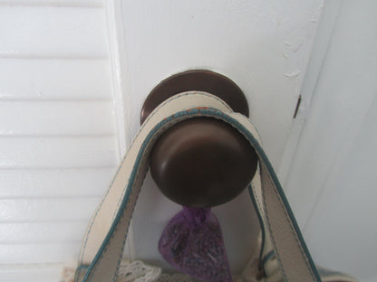 Close-up of a brown doorknob on a white door with a purple object attached.