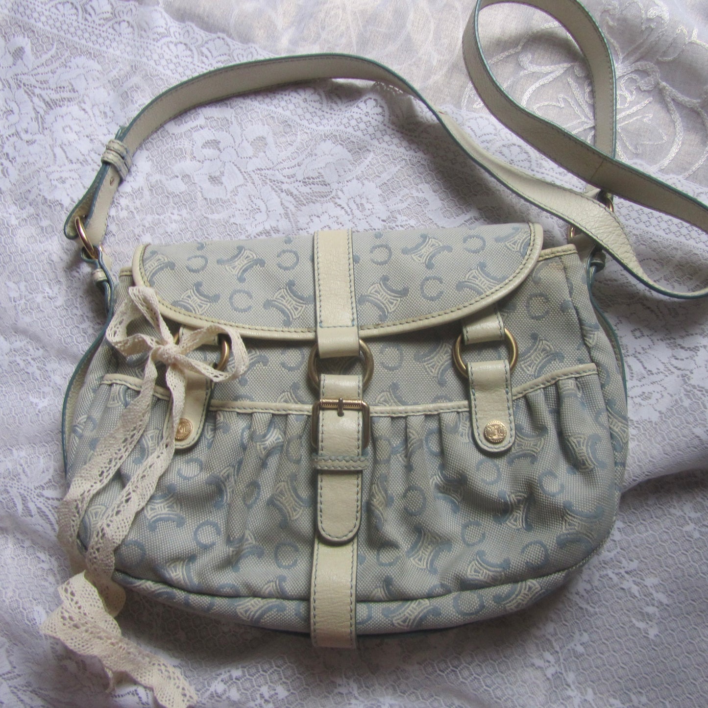 Light blue handbag with lace details on a textured white background