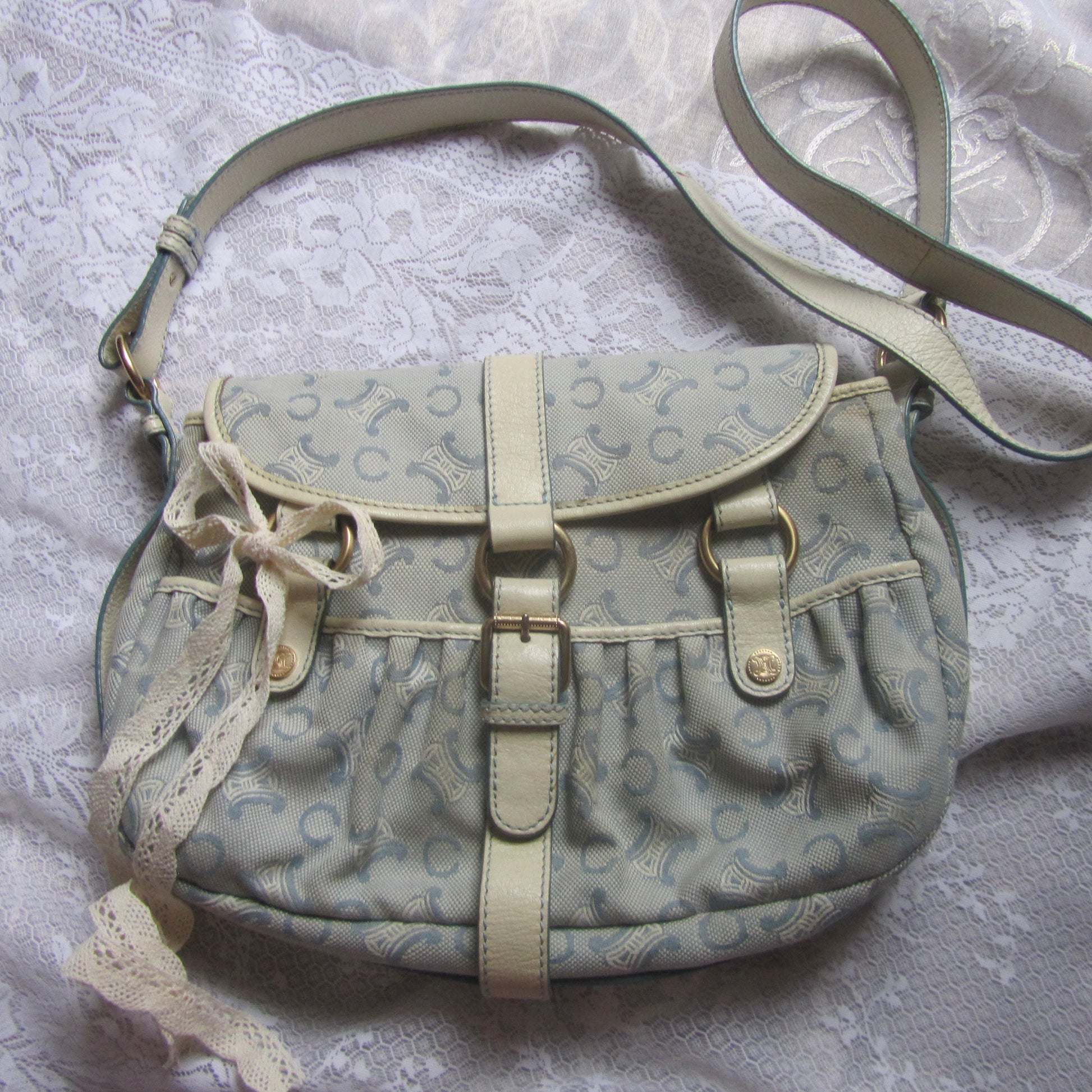 Light blue handbag with lace details on a textured white background