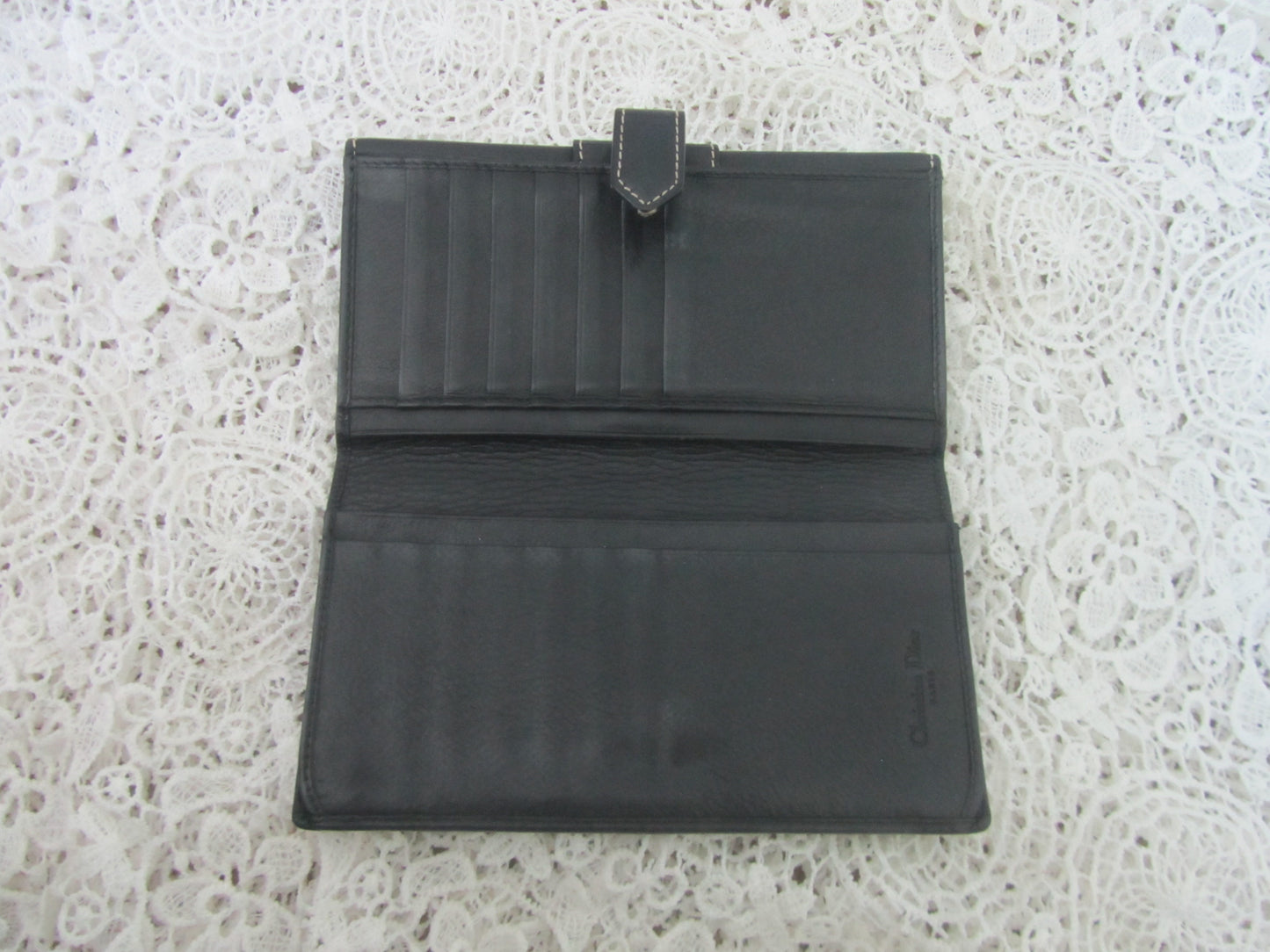 Black leather wallet on a textured white surface
