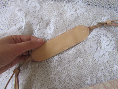 Hand holding a leather strap against a lace background