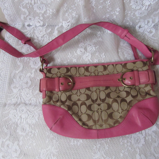 Pink and beige handbag with a visible brand logo on a white lace tablecloth.