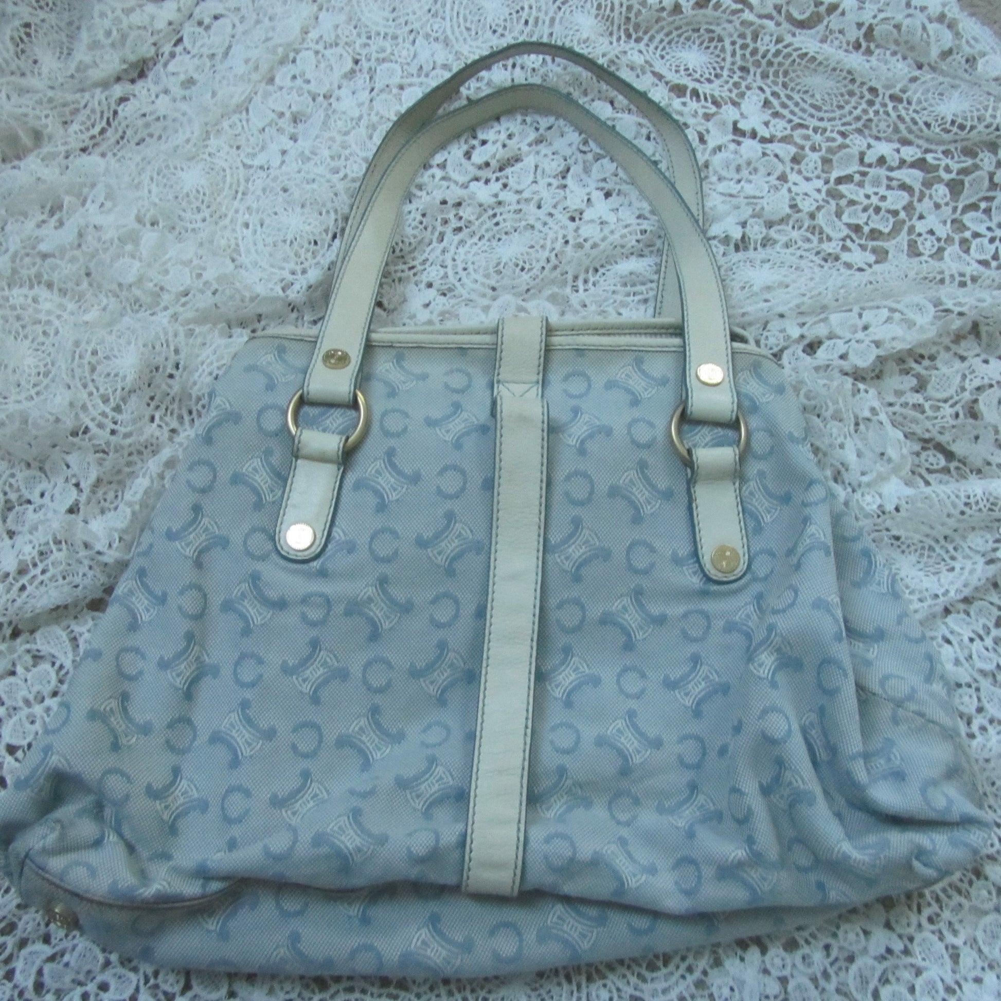 Light blue handbag with a pattern on a textured surface