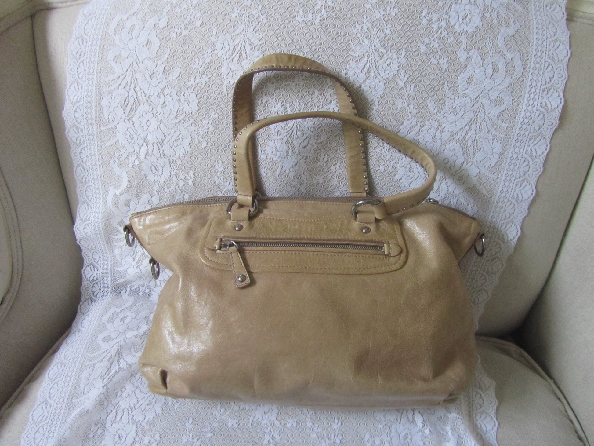 Beige handbag on a white textured surface