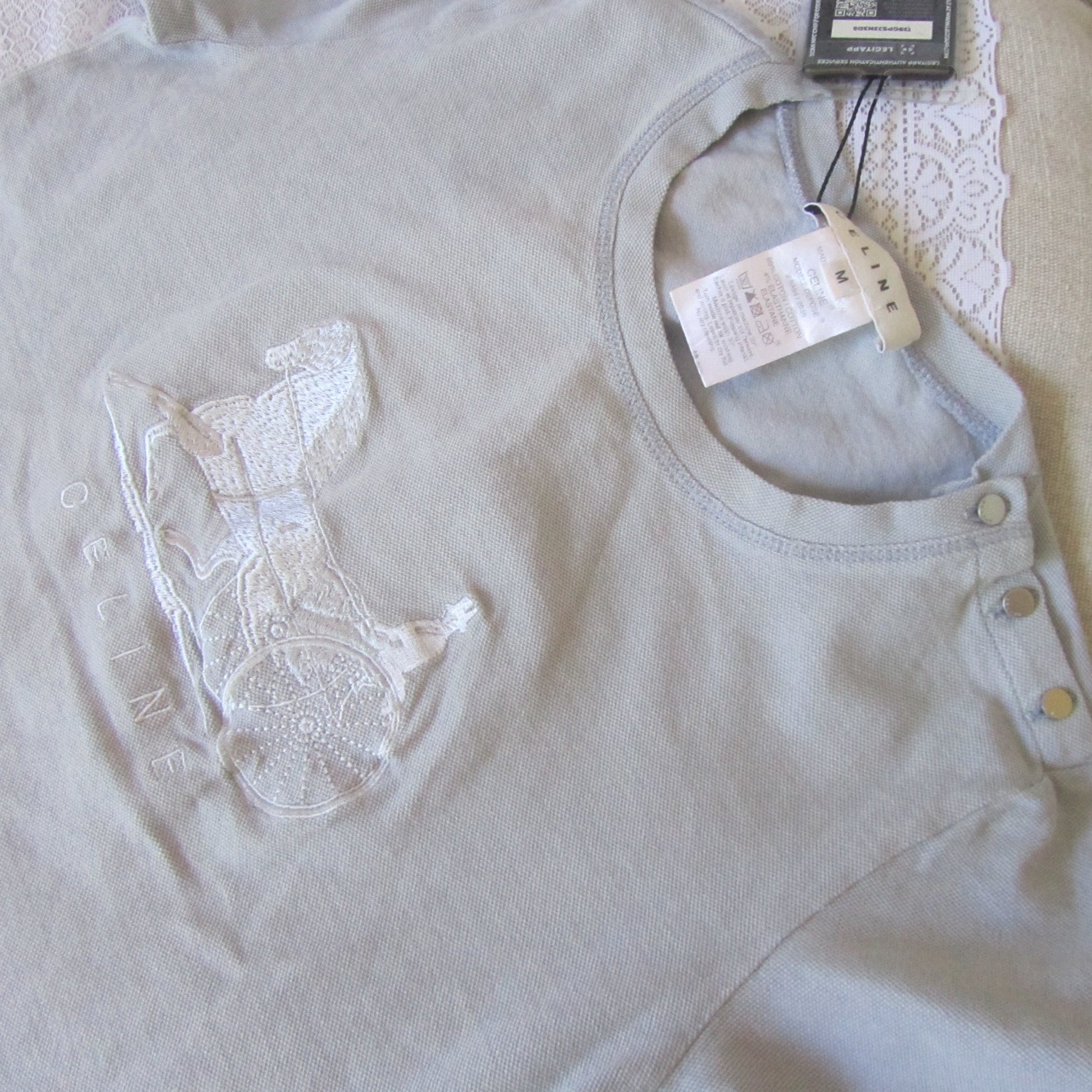 Light blue   shirt with lace detailing on a white background