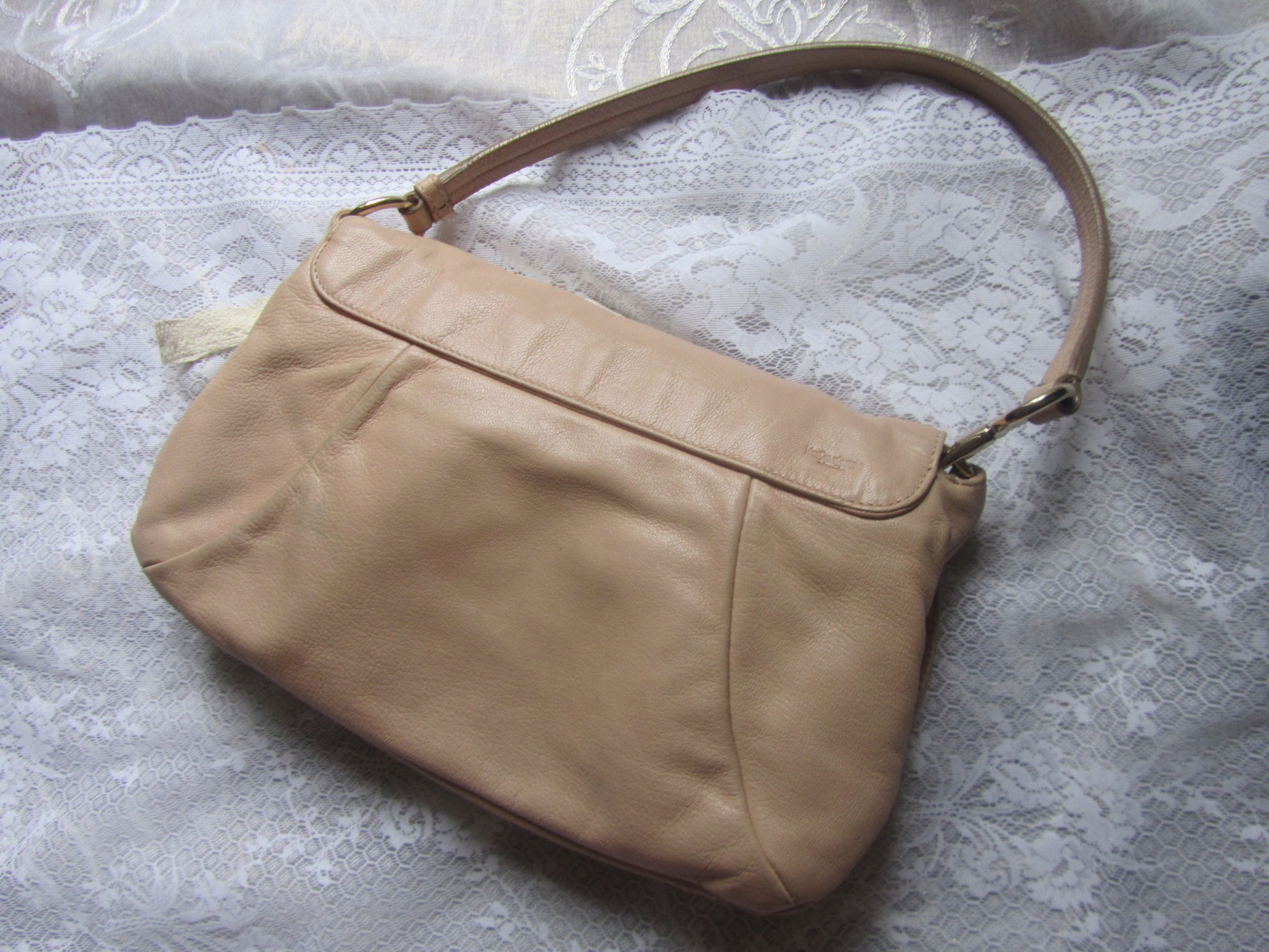 Beige handbag on a textured white surface