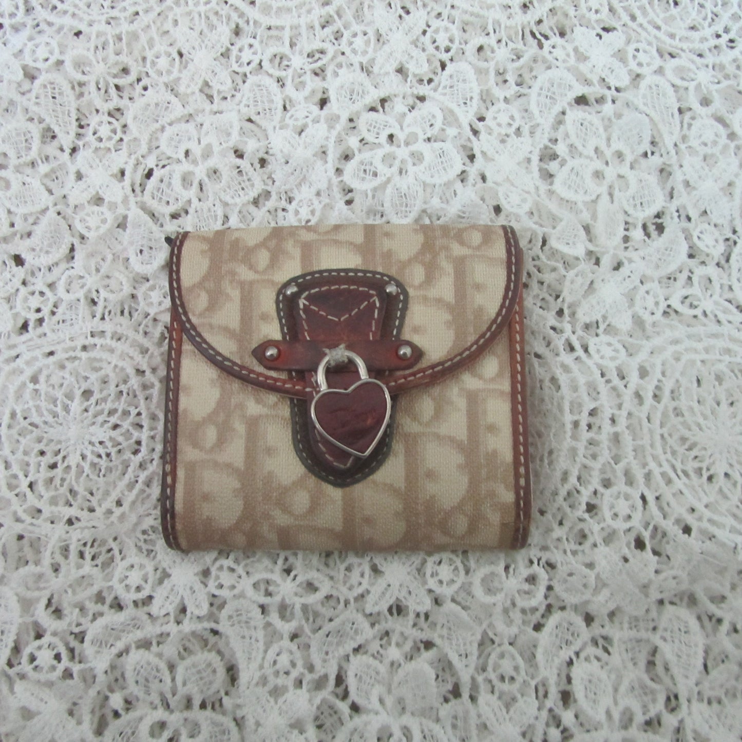 Small wallet with a heart-shaped clasp on a lace background