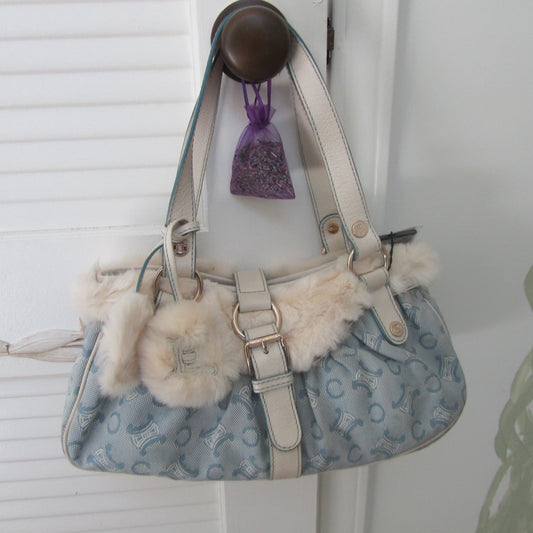 Handbag with fur accents and a purple tag on a white background