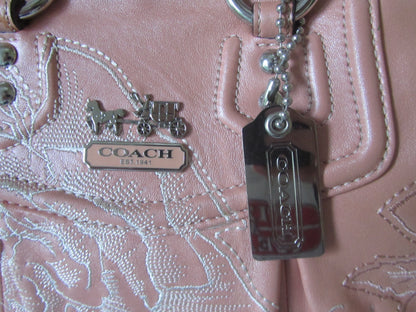 Close-up of a Coach handbag with branding and keychain.