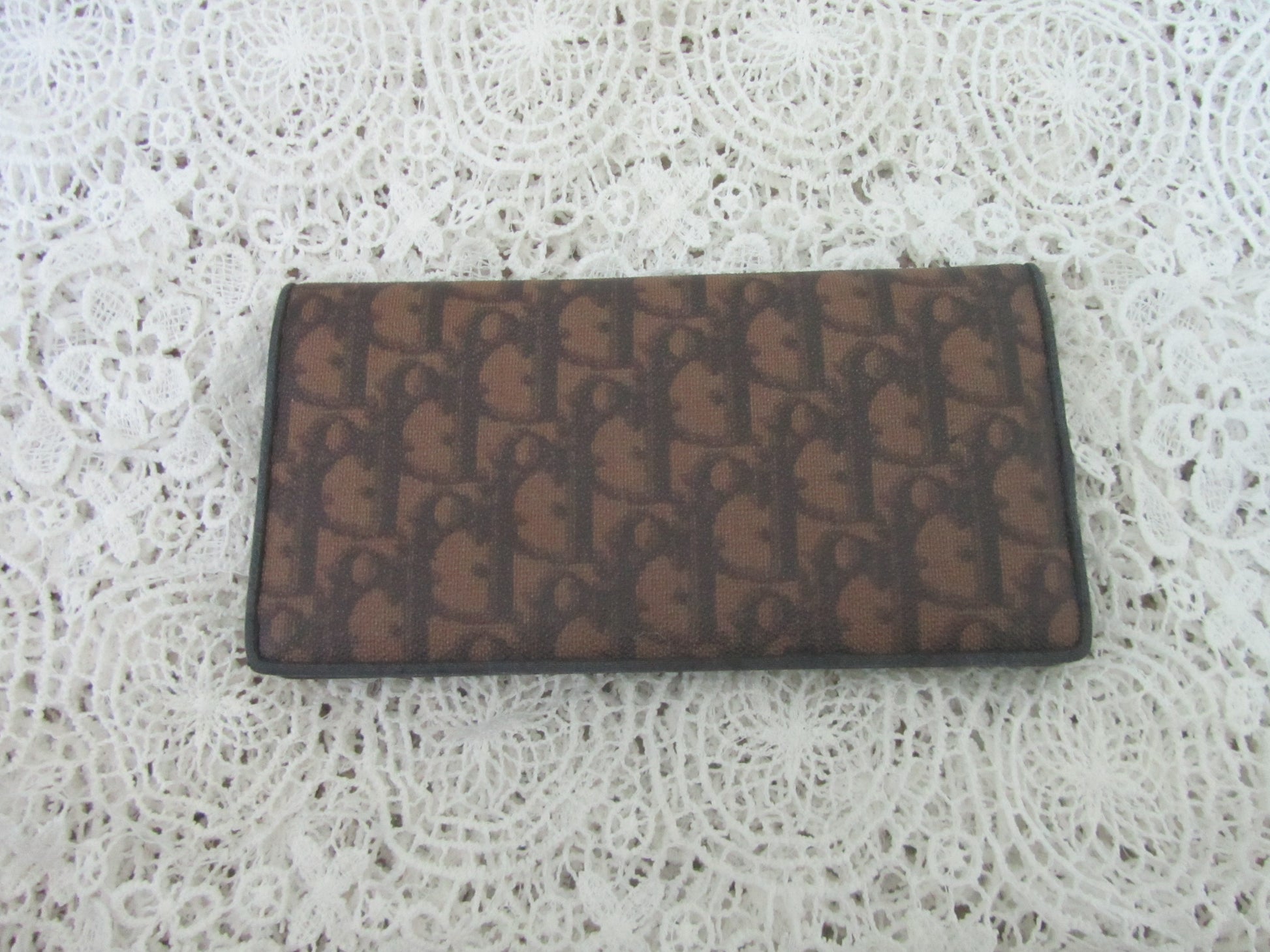 Brown wallet with a pattern on a textured white surface