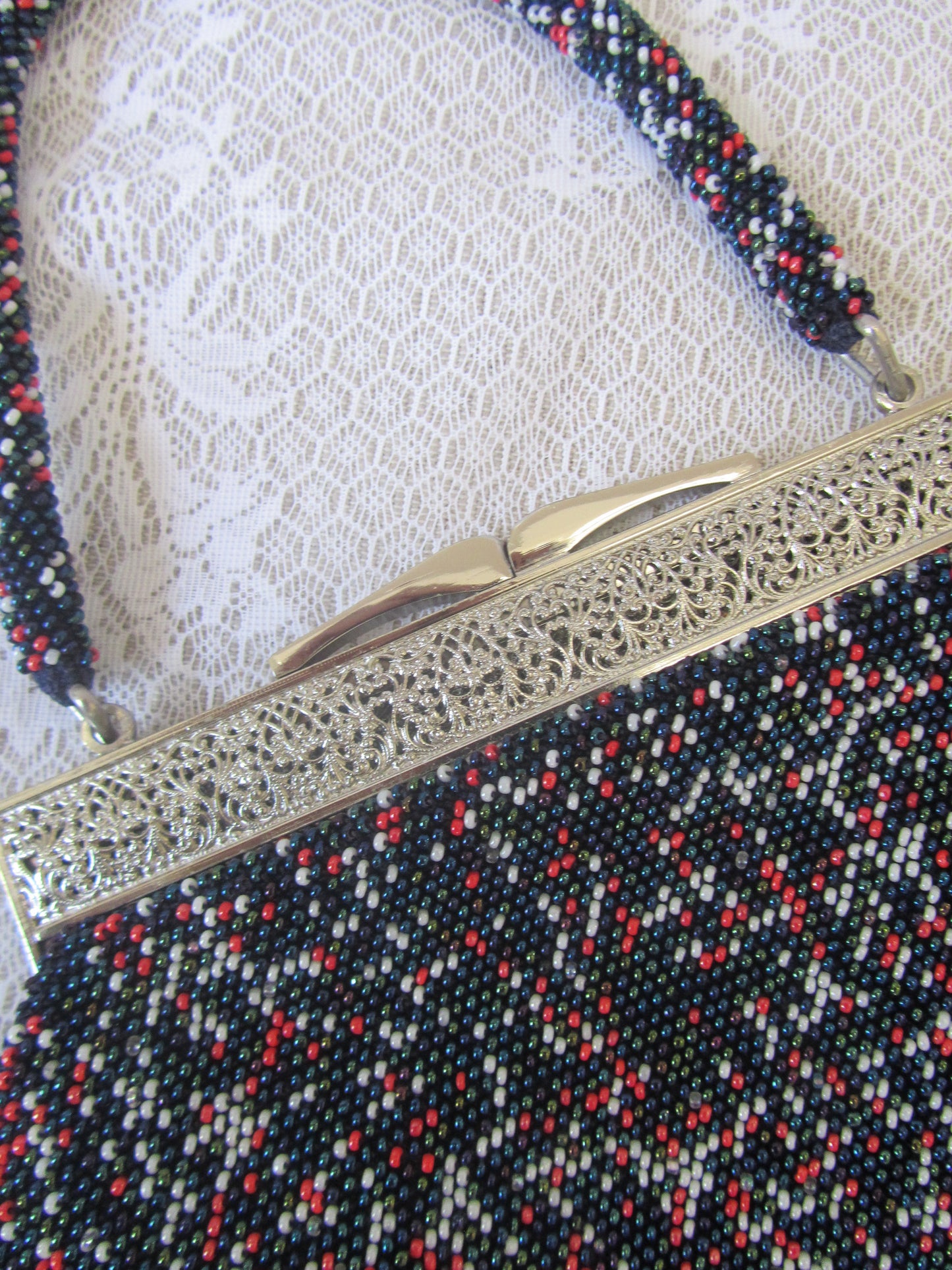 Close-up of a decorative metal object with intricate patterns on a textured fabric background.