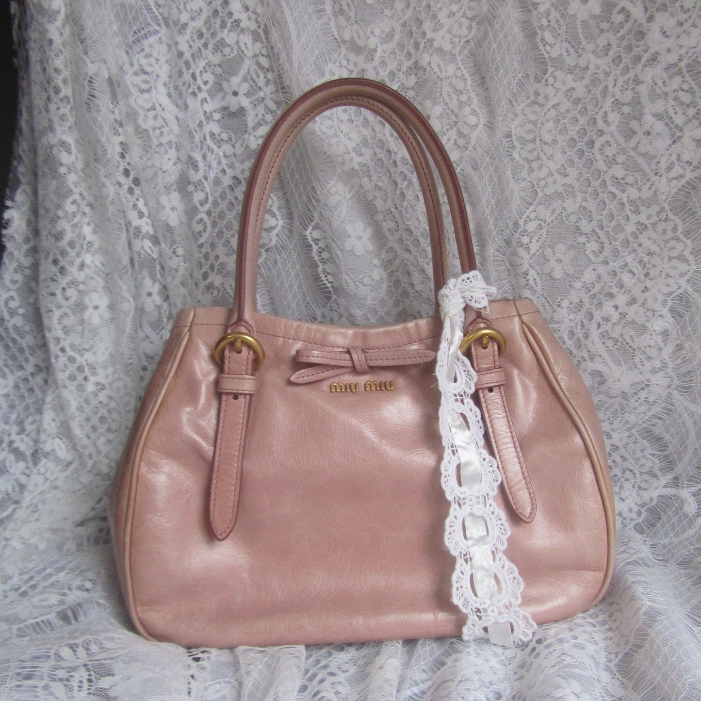 Pink handbag with lace trim on a lace background