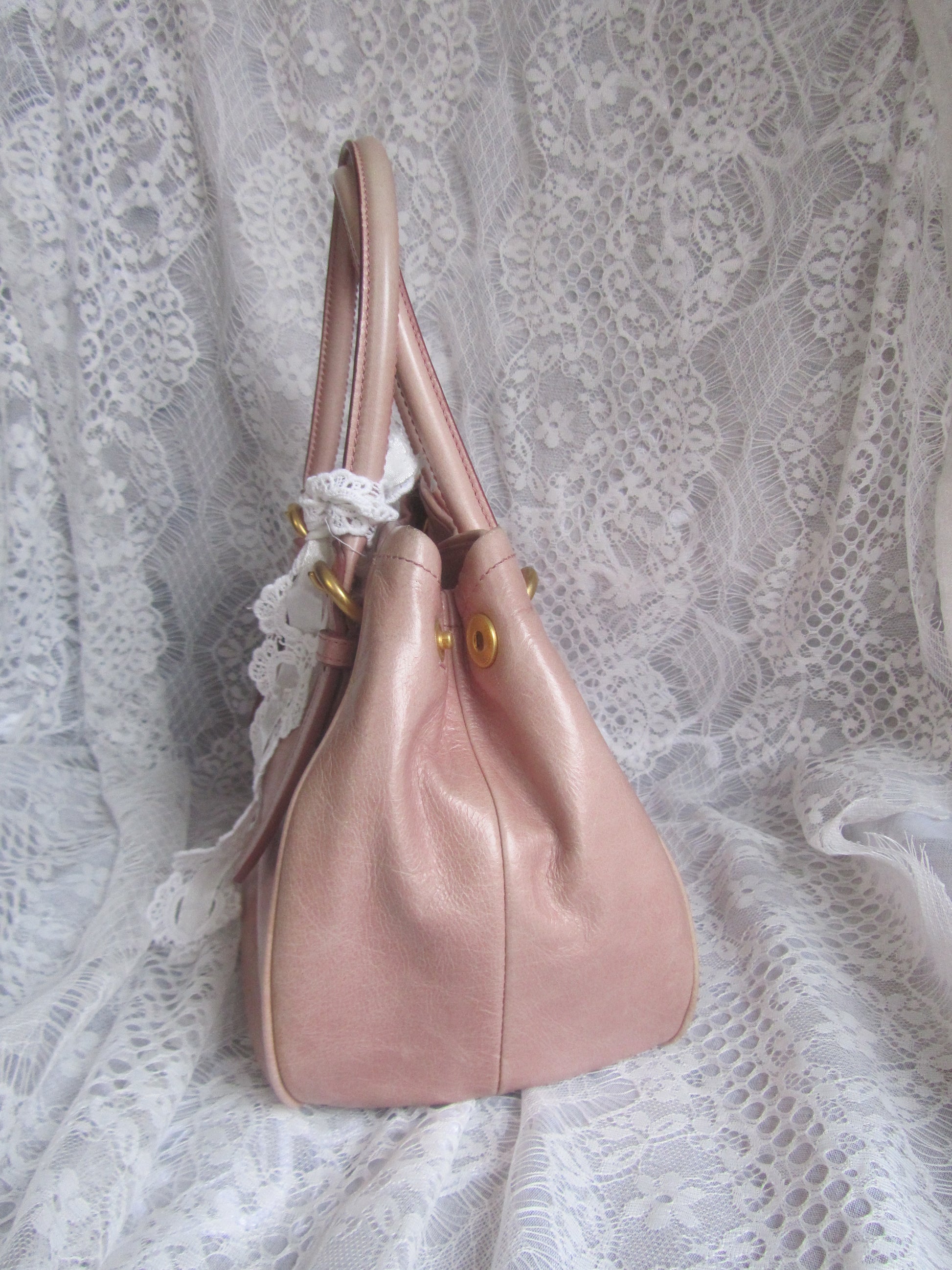 Pink handbag on a lace fabric background