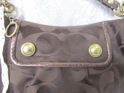 Close-up of a brown handbag with gold accents on a white background