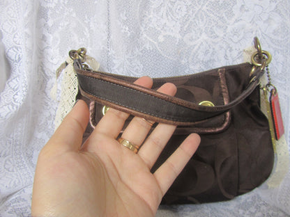 Brown handbag held by a hand against a textured white background