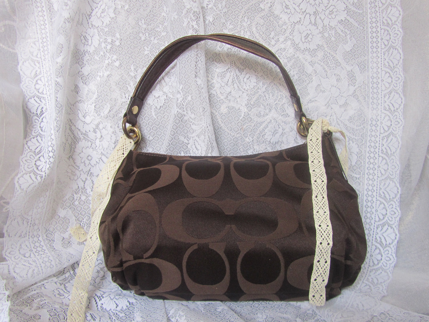 Brown handbag with a pattern on a white lace background