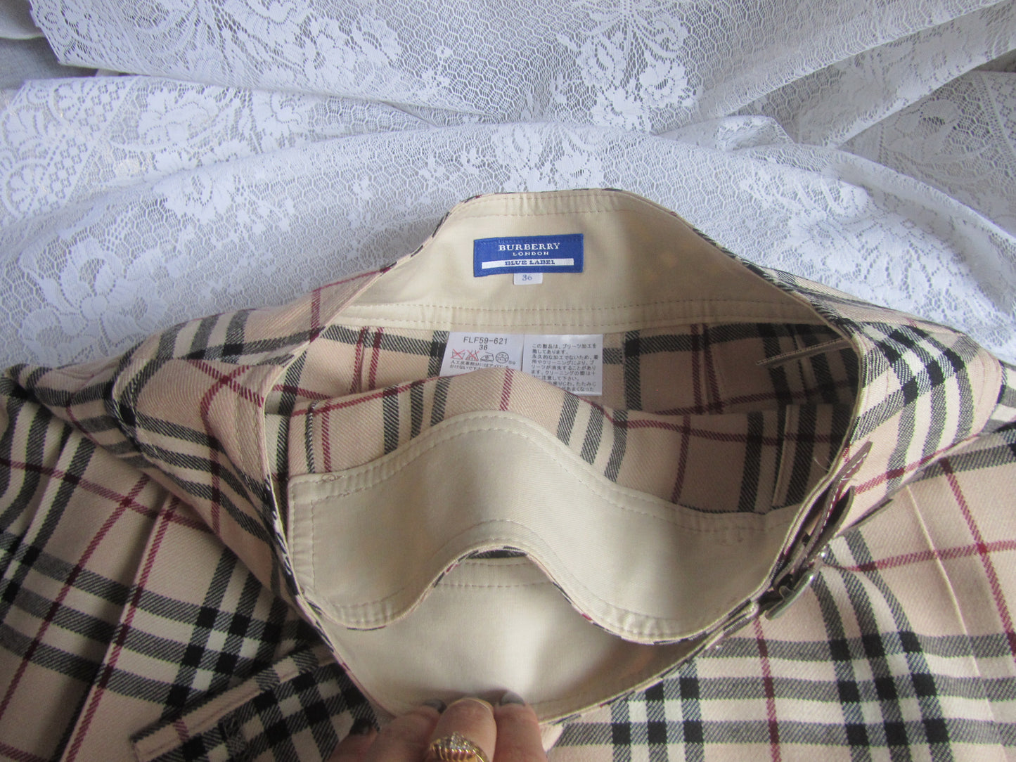 Plaid shirt with a visible tag on a textured white surface
