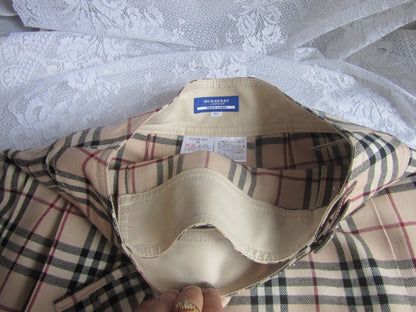 Plaid shirt with a visible tag on a textured white surface